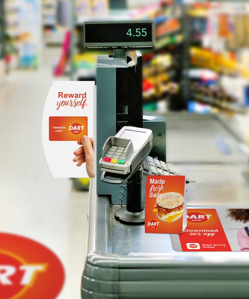 grocery store checkout register with branded signage