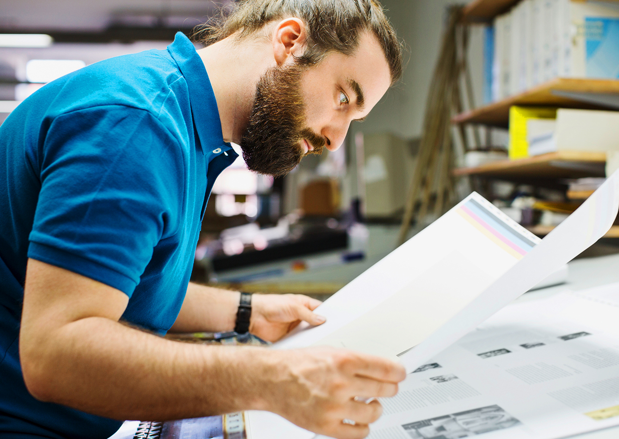 An employee inspecting a bindery plan