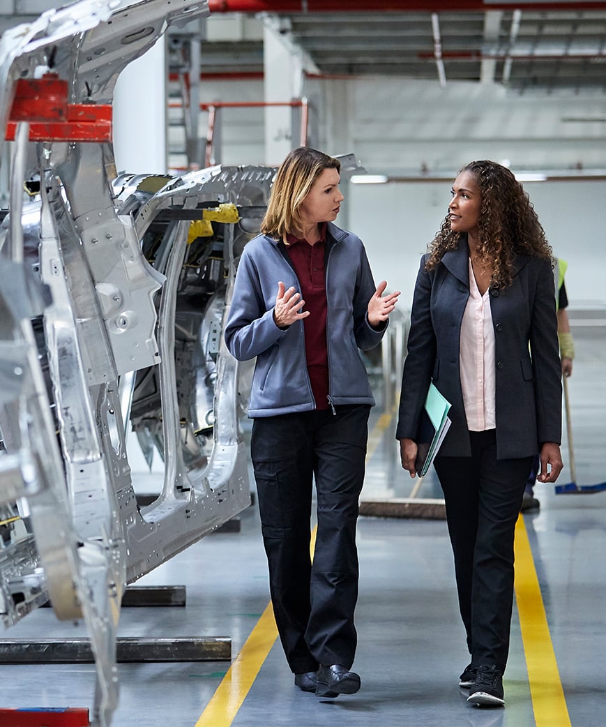 Two service representatives collaborating in an automotive manufacturing facility