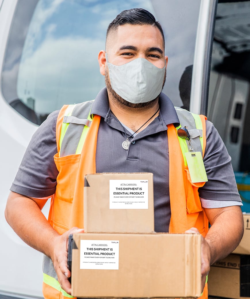 Delivery man in facemask delivering two packages